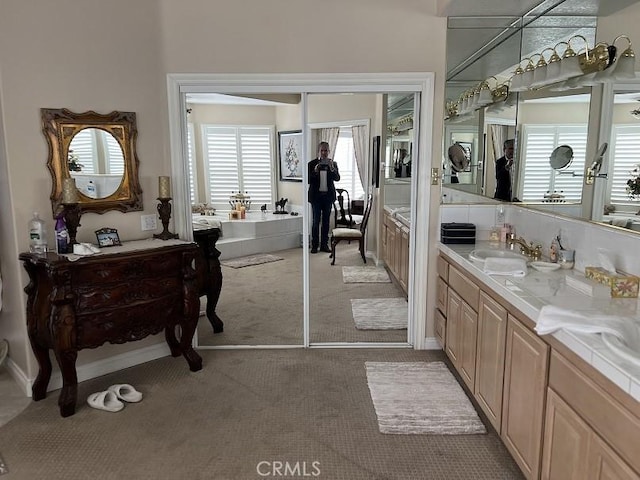 bathroom featuring a garden tub and vanity