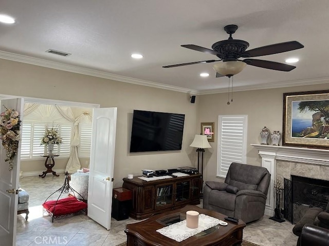 living area featuring visible vents, crown molding, and a tile fireplace