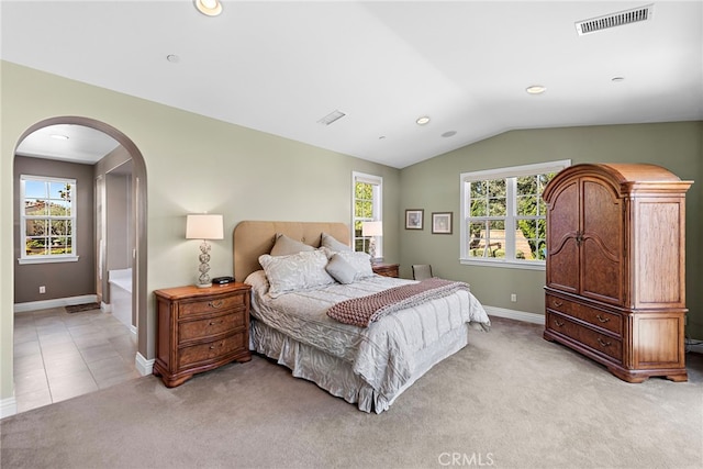 bedroom featuring light carpet, baseboards, visible vents, arched walkways, and lofted ceiling