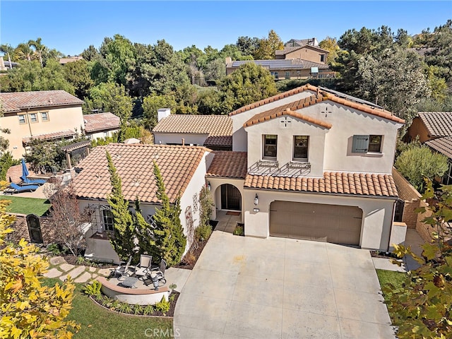 view of front of house featuring driveway, a tile roof, a garage, and stucco siding