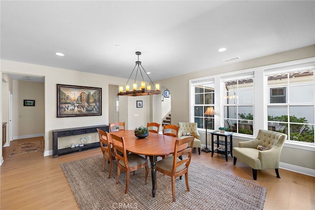 dining area featuring a notable chandelier, recessed lighting, baseboards, stairway, and light wood finished floors