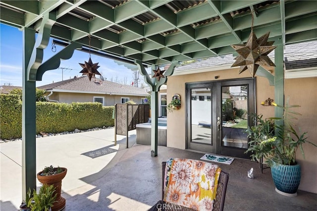 entrance to property featuring stucco siding, a hot tub, fence, and a patio