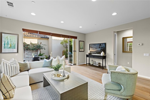 living area with baseboards, light wood finished floors, visible vents, and recessed lighting