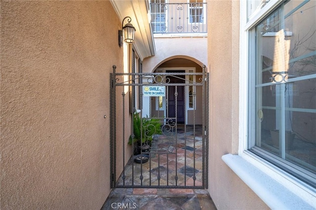 doorway to property with a gate and stucco siding