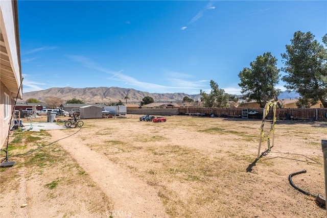 view of yard featuring a mountain view and fence