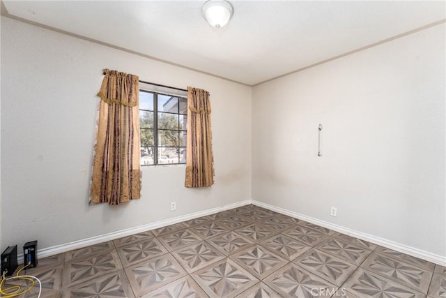 unfurnished room featuring baseboards and crown molding