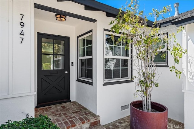 property entrance featuring crawl space and stucco siding