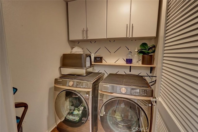 washroom with cabinet space and washing machine and clothes dryer