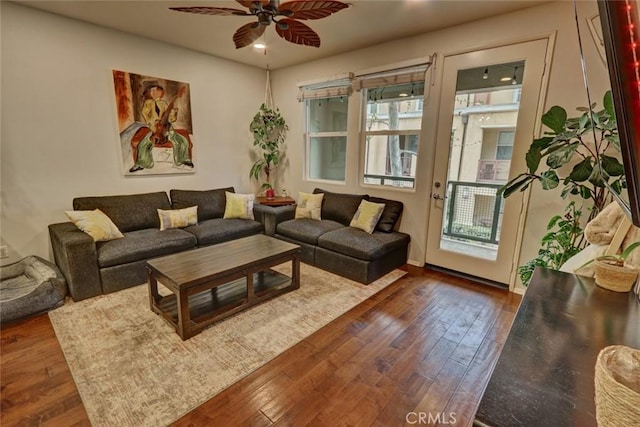 living area with ceiling fan and dark wood-style flooring