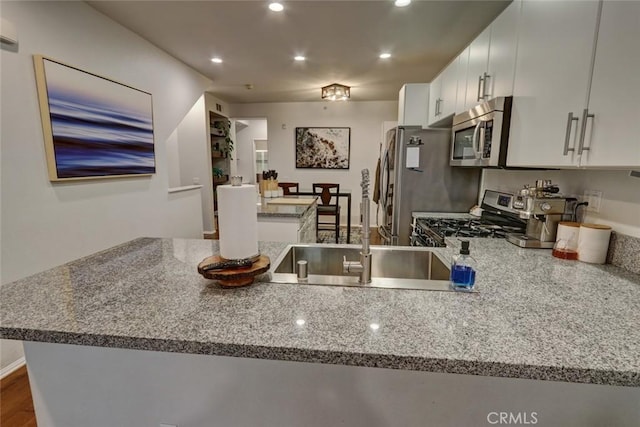 kitchen with light stone counters, dark wood finished floors, recessed lighting, appliances with stainless steel finishes, and white cabinets