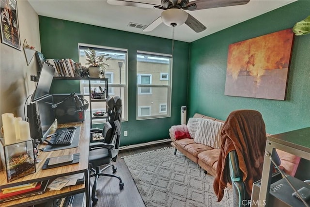 office featuring a ceiling fan, visible vents, and wood finished floors