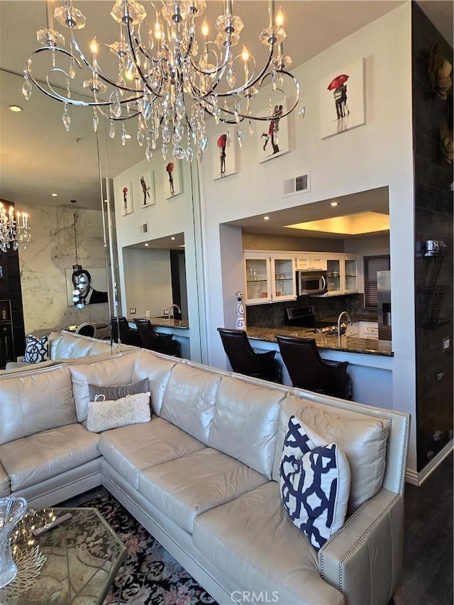 living room featuring a towering ceiling, wood finished floors, visible vents, and recessed lighting