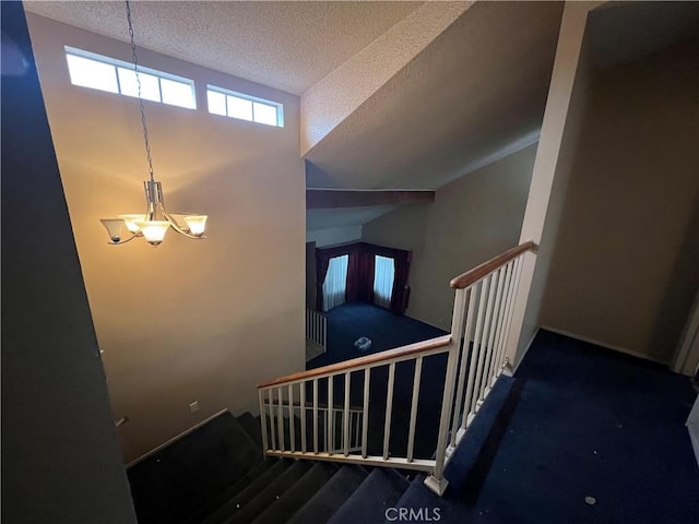 staircase with baseboards, a chandelier, and a textured ceiling