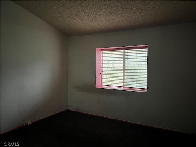 unfurnished room featuring baseboards and a textured ceiling