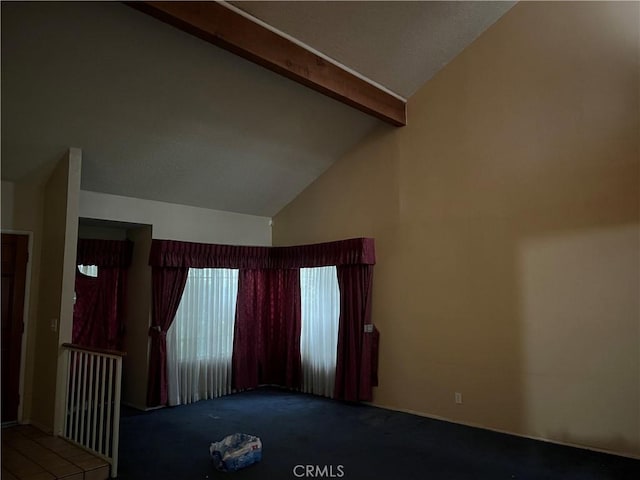 carpeted spare room with beam ceiling and high vaulted ceiling