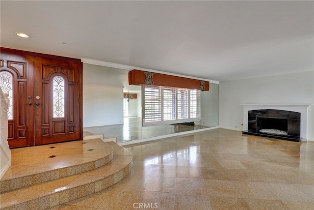 entryway featuring ornamental molding, granite finish floor, a high end fireplace, and baseboards