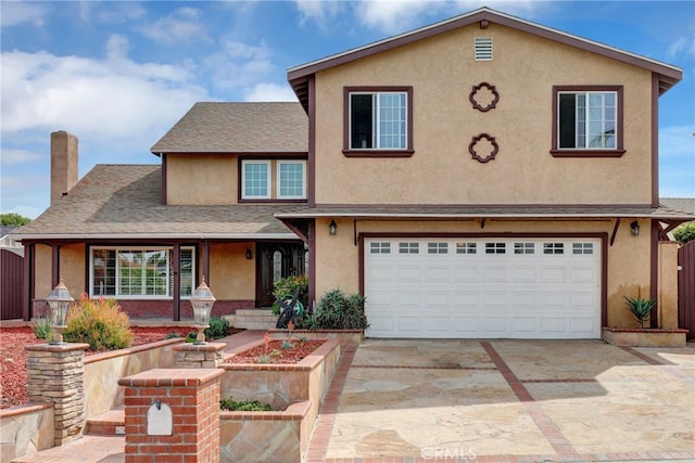 view of front of house featuring an attached garage, driveway, a chimney, and stucco siding