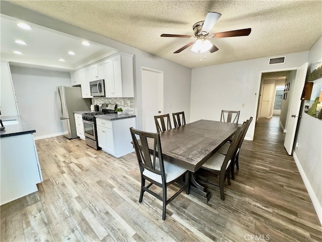 dining space with visible vents, ceiling fan, light wood-style flooring, and baseboards