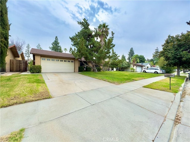 ranch-style house featuring an attached garage, driveway, a front yard, and fence