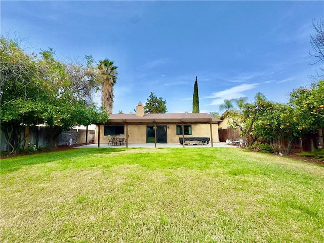 back of house featuring a patio area, a fenced backyard, and a lawn