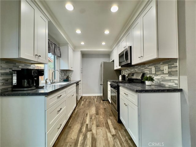 kitchen featuring stainless steel appliances, dark wood-style flooring, white cabinets, and a sink