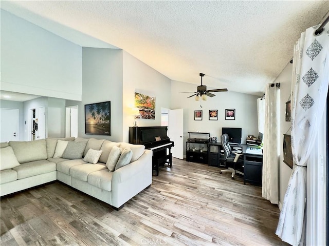 living area featuring high vaulted ceiling, a textured ceiling, a ceiling fan, and wood finished floors