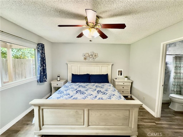 bedroom with a textured ceiling, baseboards, dark wood-style flooring, and ensuite bathroom