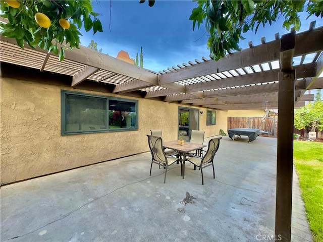 view of patio featuring outdoor dining space, fence, and a pergola