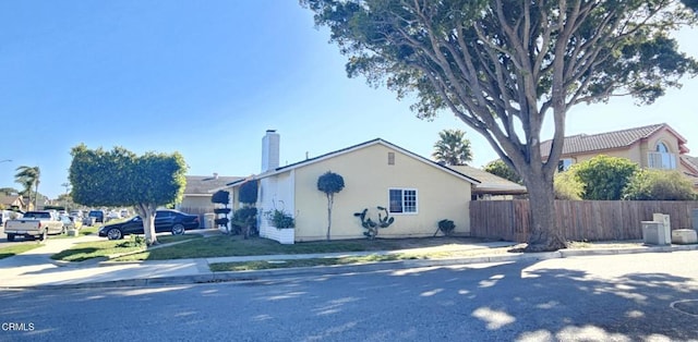 view of front of house featuring a chimney and fence