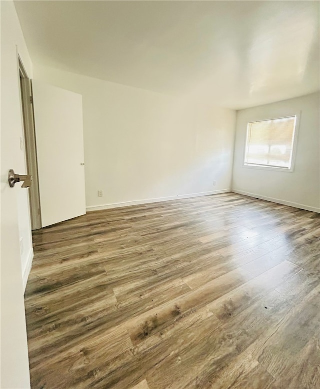 empty room with baseboards and wood finished floors