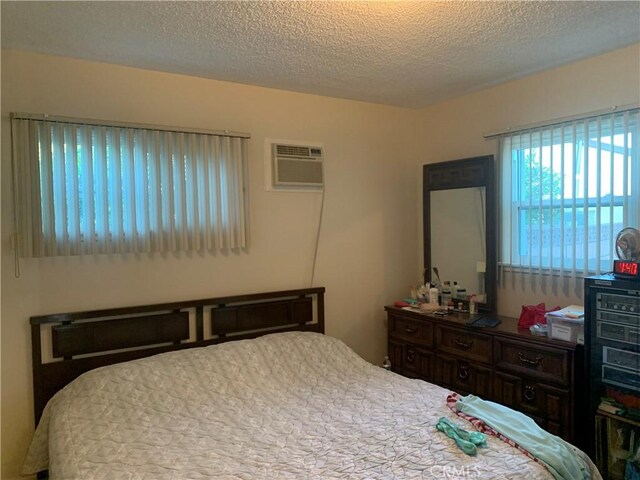 2665 Millet Ave, El Monte, CA 71733 - bedroom featuring a wall unit AC and a textured ceiling