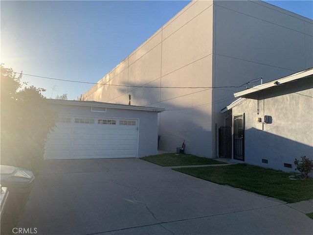 view of side of home with a detached garage and stucco siding