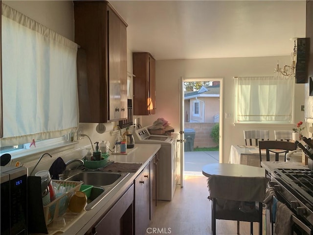 2665 Millet Ave, El Monte, CA 71733 - kitchen featuring dark brown cabinetry, washer / clothes dryer, light countertops, light wood-style floors, and a sink