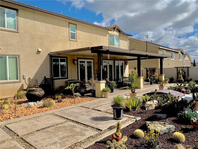 back of house featuring french doors, a patio area, and stucco siding