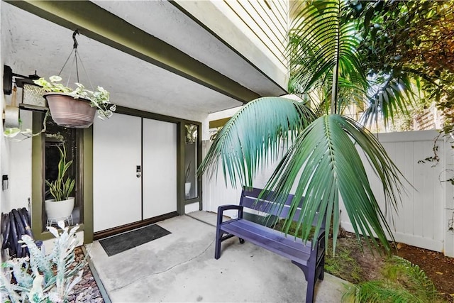 doorway to property with fence and a patio