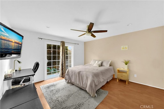 bedroom featuring access to exterior, a ceiling fan, and light wood-style floors