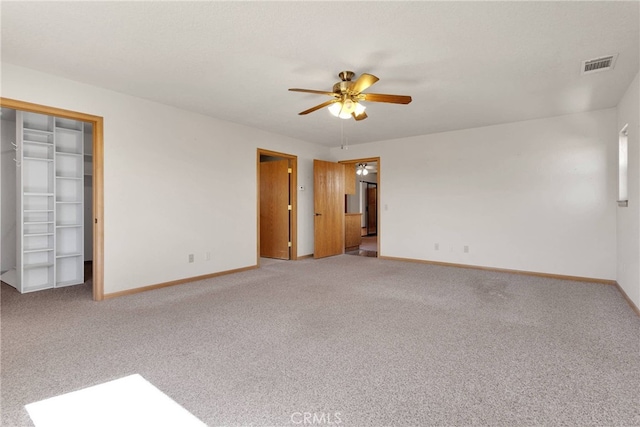 unfurnished bedroom with a ceiling fan, baseboards, visible vents, and carpet flooring