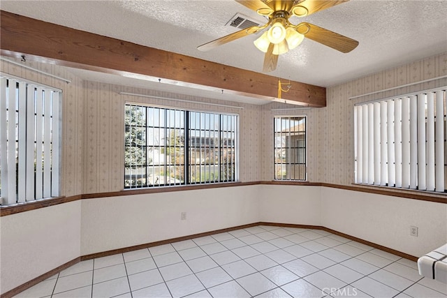 empty room featuring a textured ceiling, beam ceiling, and wallpapered walls