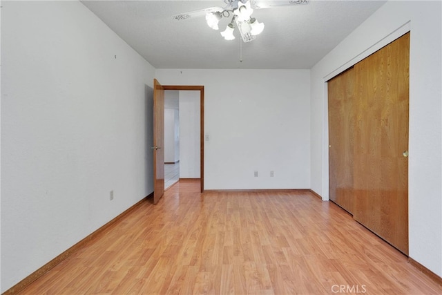 unfurnished bedroom with light wood-type flooring, ceiling fan, baseboards, and a closet