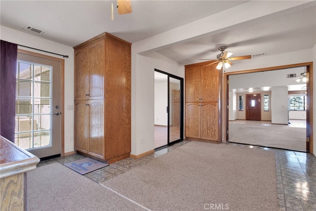 interior space featuring visible vents, ceiling fan, and baseboards