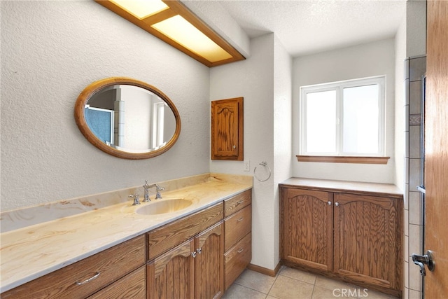 bathroom featuring a textured ceiling, a textured wall, vanity, and tile patterned floors