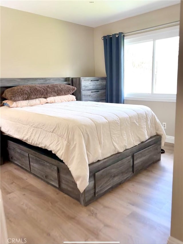 bedroom with wood finished floors and baseboards
