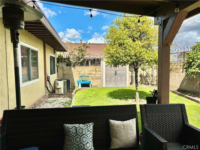 view of yard with an outbuilding, central AC unit, a fenced backyard, and a shed