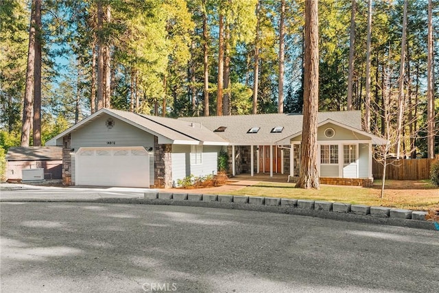 single story home featuring a garage, a front yard, concrete driveway, and fence