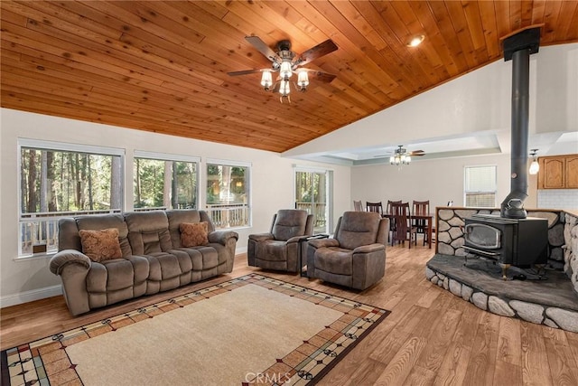 living room with wood ceiling, light wood-style flooring, and a wood stove