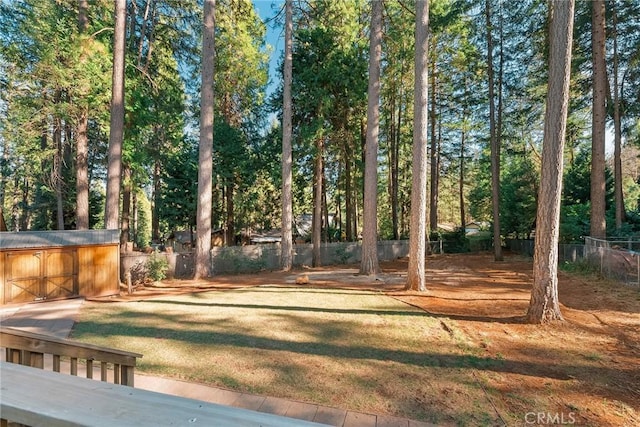 view of yard featuring an outdoor structure, a storage shed, and fence