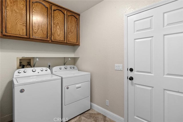 laundry room featuring cabinet space, baseboards, and separate washer and dryer