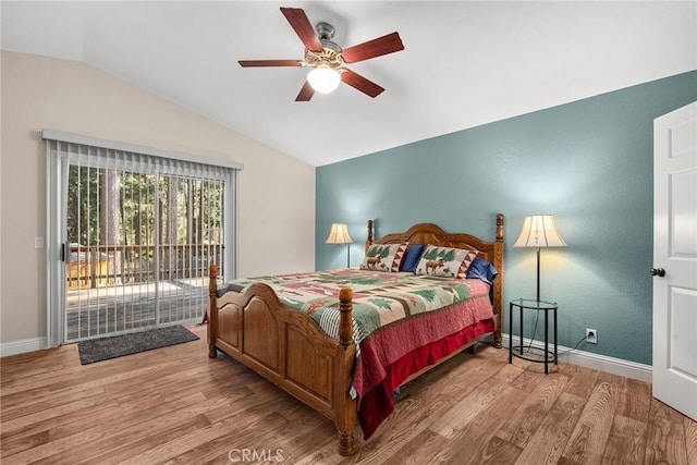 bedroom featuring access to exterior, vaulted ceiling, baseboards, and wood finished floors