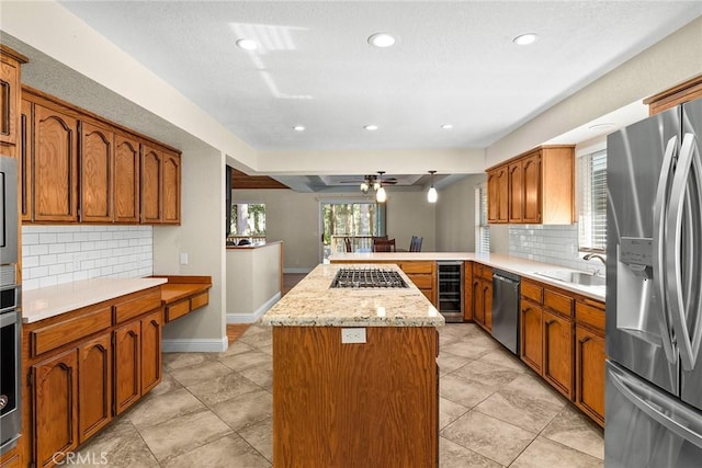 kitchen featuring beverage cooler, brown cabinets, a peninsula, stainless steel appliances, and a sink