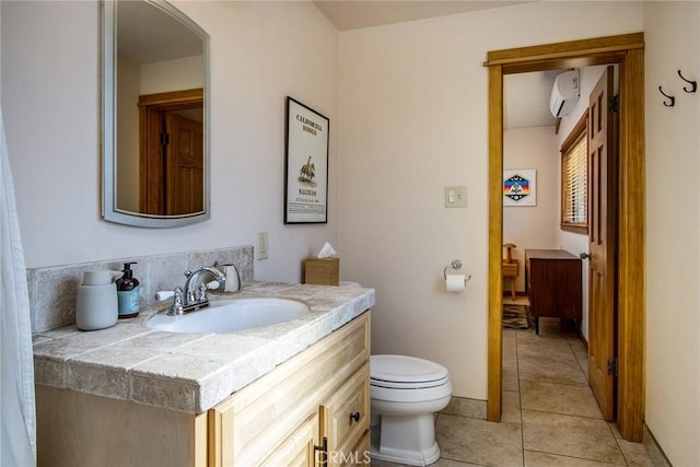 7716 Sunset Rd, Joshua Tree, CA 92252 - bathroom with vanity, an AC wall unit, toilet, tile patterned floors, and baseboards